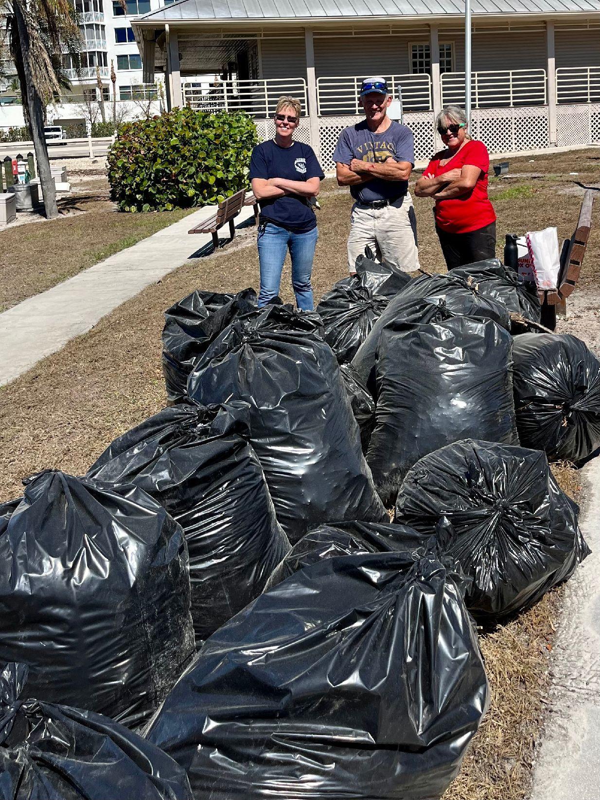 Ellen DeLeo, Terry Schwinghammer, and Heidi LaQuadra pose proudly with some of the 28 bags they packed with hurricane debris outside the Wiggins Pass Flotilla meeting place on October 22, 2022
